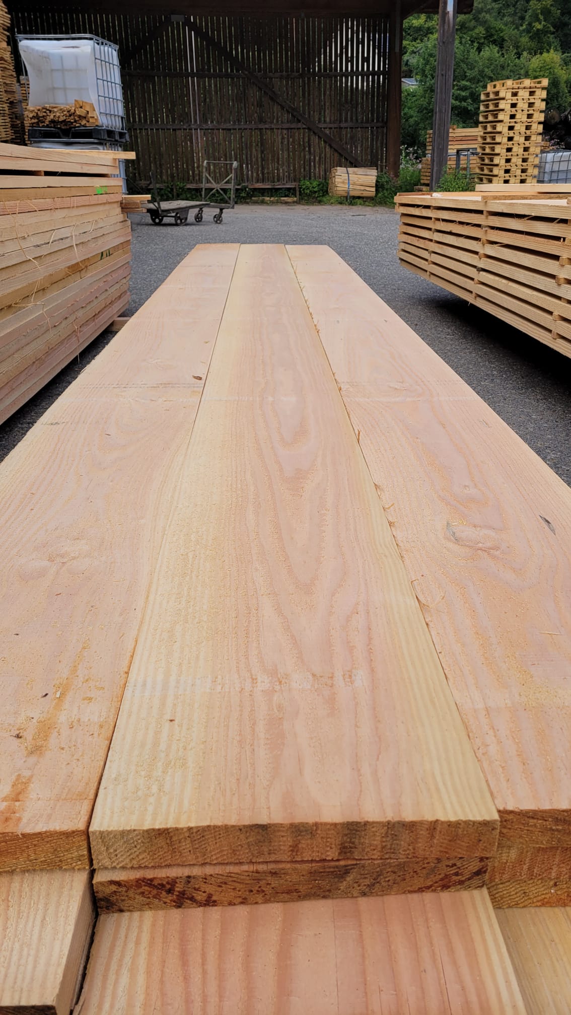 Long flooring-grade oak boards staged at the yard